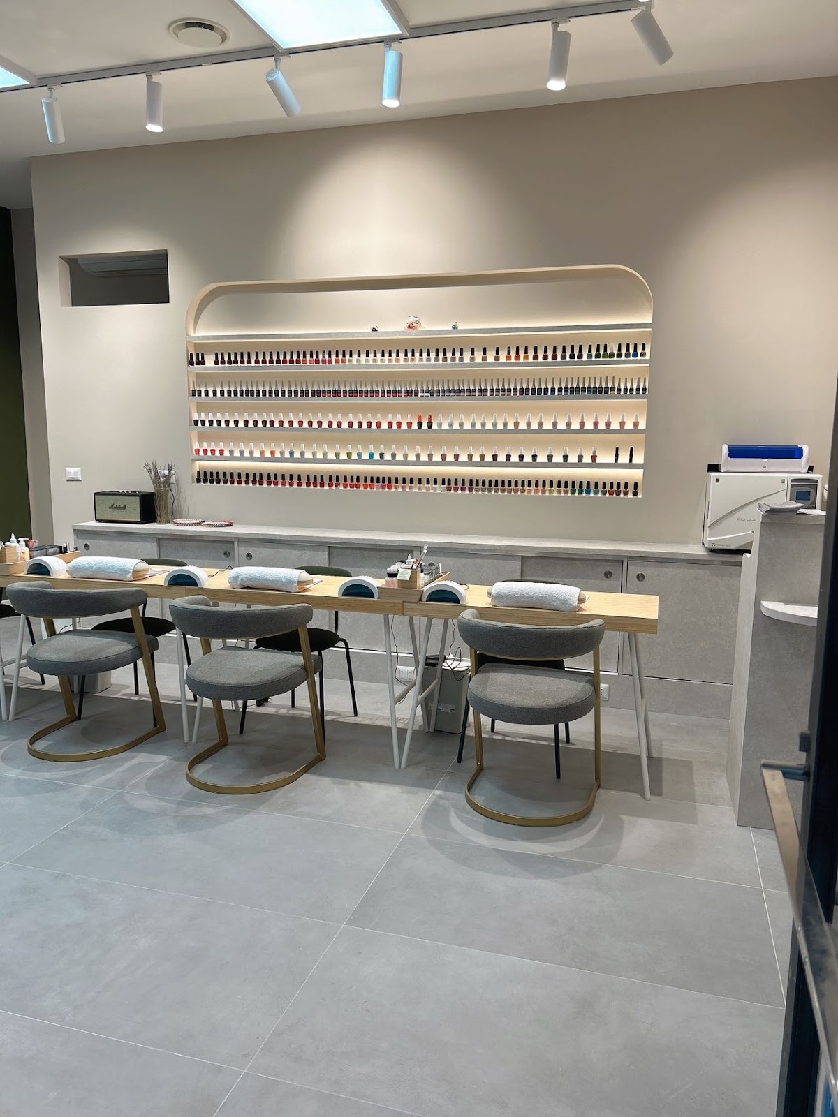 Sala manicure con parete retroilluminata degli smalti